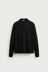 Polo de punto color negro, de corte regular fit, con cuello solapa, cierre frontal de dos botones y manga larga.