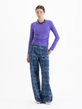 Top de lycra color violeta, con cuello redondo, mangas largas y detalle de frunces laterales en la cintura que aportan movimiento a la prenda.