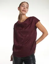 Blusa de satén labrado con diseño de jacquard tono sobre tono, cuello volcado y manga corta con hombro caído.