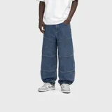 Pantalón de jean azul ultra baggy con costuras horizontales segmentadas y diseño holgado.