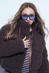 Campera puffer de corderito negro con cuello alto y diseño oversized. Presenta una textura tipo teddy, cierre frontal y corte a la cintura.