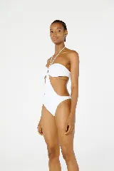 Traje de baño enterizo blanco con escote strapless, abertura en el abdomen y breteles finos que se atan al cuello.