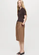 Short de gabardina marrón de tiro medio, diseño recto tipo bermuda, con pinzas en la parte delantera, bolsillos laterales y cinturón ajustable incorporado.