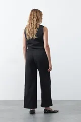 Pantalón wide leg color marrón chocolate, de tiro medio y corte relajado. Presenta detalle de hebillas laterales con ojales metálicos en la cintura y una caída fluida.