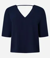 Blusa Cortelle de corte holgado confeccionada en crepé, con escote en V delantero y trasero, y mangas cortas. Presenta una tira decorativa entre los hombros en la espalda.