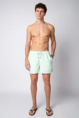 Short de baño color verde menta con efecto desgastado, cintura elástica con cordón ajustable y bolsillos laterales.