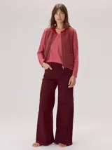 Pantalon de corte ancho y holgado, color verde militar, con diseño de tiro medio, pinzas decorativas debajo de la rodilla, bordado de monograma en el bolsillo delantero y costuras a contratono.