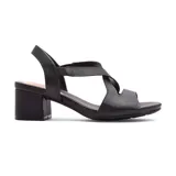 Sandalias negras de cuero sintético con tiras cruzadas y elástico en el tobillo. Taco cuadrado de altura media.