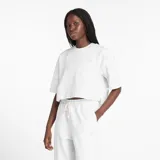 Remera blanca de New Balance, corte crop y logo pequeño en el pecho.