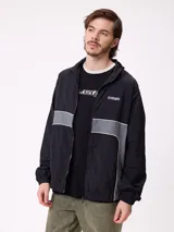 Rompevientos Rusty con cierre frontal, capucha y diseño de bloques de color en gris y verde militar. Cuenta con puños elásticos y logo de la marca en el pecho.