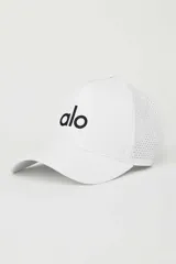 Gorra tipo trucker de alto rendimiento, color blanco con logo negro bordado en el frente. Presenta una corona estructurada y paneles traseros con perforaciones para mayor ventilación, con cierre ajustable de velcro.
