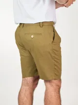 Bermuda color beige confeccionada en lino, con bolsillos laterales y traseros, y presillas para cinturón.
