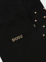 Set de dos pares de medias Boss de color negro, con diseño de lunares pequeños y logo de la marca bordado en tono dorado.