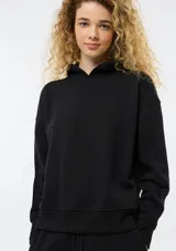 Buzo de felpa color negro con capucha, diseño liso, corte holgado y puños elásticos en mangas y ruedo.