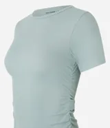 Remera deportiva de manga corta confeccionada en microfibra, con cuello redondo y diseño ajustado con fruncidos en los laterales.