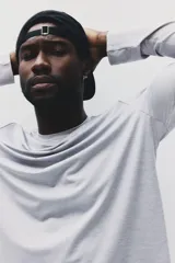 Remera deportiva de manga larga con cuello redondo, confeccionada en tejido funcional transpirable con tecnología DryMove que absorbe el sudor. Presenta un diseño liso con aberturas laterales en el bajo y corte estándar.