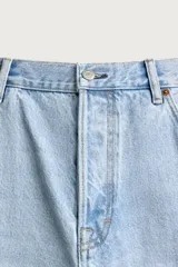 Bermuda de jean con corte holgado y pierna recta, confeccionada en denim de algodón rígido con efecto lavado. Presenta diseño clásico de cinco bolsillos y cierre frontal con botones.