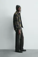 Sobrecamisa de corte relajado confeccionada en tejido con textura efecto pelo. Presenta diseño de cuadros en tonos verde y negro, cuello solapa, cierre frontal con botones, manga larga con puños abotonados y un bolsillo de plastrón en el pecho.