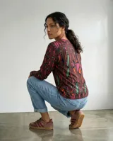 Remera de manga larga con cuello redondo, confeccionada en tela con estampa exclusiva de formas orgánicas en tonos vino, ciruela, verde, coral y fucsia.