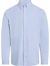 Camisa de manga larga Calvin Klein, confeccionada en sarga de algodón. Presenta cuello abotonado, cierre frontal con botones y logo de la marca bordado sutilmente en el pecho.
