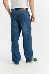 Jean cargo de algodón con calce suelto, color negro lavado con efecto desgastado, con múltiples bolsillos utilitarios en los laterales.