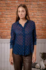 Camisa de manga larga con estampado de leopardo, cuello clásico y cierre frontal de botones. Presenta un corte holgado y puños abotonados.