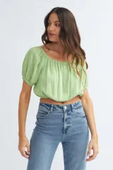 Blusa roja con escote cuadrado, mangas cortas abullonadas y cierre frontal con botones.