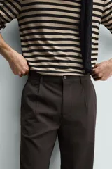 Pantalón de corte recto confeccionado en tejido elástico, con cintura elástica, pliegues frontales, bolsillos laterales y bolsillos traseros de vivo con botón.