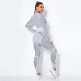 Calza deportiva gris con paneles de tela calada en las piernas.