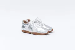 Zapatillas Magnolia de cuero negro con detalles en blanco y suela marrón.