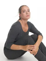 Enterito de tejido de punto con textura canalé, color gris oscuro. Presenta escote redondo, mangas tres cuartos y cintura elastizada con lazo de ajuste. La parte inferior tiene un calce relajado tipo jogger con puños elastizados y bolsillos laterales.