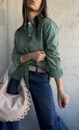 Camisa de manga larga color verde militar, con cuello camisero, cierre frontal de botones y detalles de bordados y calados en el frente y las mangas.