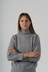 Sweater gris de tejido de punto, con cuello alto y mangas largas.