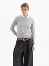 Sweater de tejido de punto color gris, con cuello redondo y cuello camisero blanco integrado. Presenta mangas largas con puños ajustados y diseño estructurado.