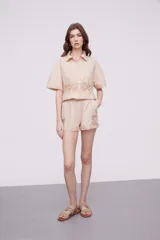 Short blanco de algodón con cintura elástica y detalles de encaje crochet en los laterales y el ruedo.