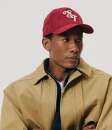 Gorra masculina de color bordó, confeccionada en tejido texturizado tipo gamuza, con visera curva, regulador y bordado frontal en lettering blanco.