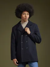 Abrigo de paño azul marino con doble botonadura, cuello con solapas y bolsillos laterales.