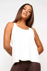 Musculosa deportiva blanca de corte holgado, con espalda estilo nadador y logo pequeño en el ruedo.