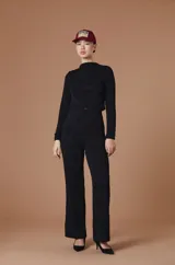 Blusa de gasa negra con cuello alto y mangas largas, de silueta fluida y diseño sofisticado.