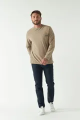 Remera de hombre negra de manga larga con puños, escote redondo y bolsillo en el pecho con etiqueta de marca.