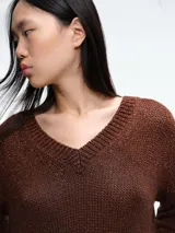Sweater de punto con brillo, de corte relajado y escote en V. Presenta hombros caídos y mangas largas con puños acanalados.