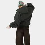 Campera con capucha y cierre frontal, color verde oscuro, con corte holgado (boxy fit). Presenta letras grandes en blanco con efecto desgastado en el pecho que dicen "EME".