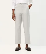 Pantalón de corte carrot con cintura alta, confeccionado en sarga de algodón con estampado de rayas verticales. Presenta un diseño holgado en la cadera que se estrecha hacia el tobillo, con bolsillos laterales y cierre frontal.
