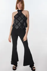 Top de cuello halter confeccionado con parches de cuero negro unidos mediante tejido de punto a crochet, creando un diseño geométrico de rombos.
