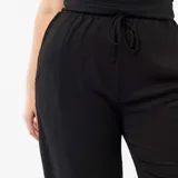 Pantalón ancho de punto crepé color negro, con diseño holgado y fluido.