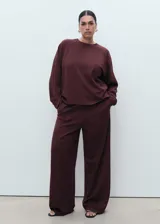 Pantalón de corte recto y pernera ancha, color bordó, con cintura elástica y bolsillos laterales.