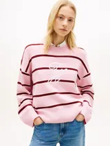 Sweater de punto Tommy Hilfiger confeccionado en puro algodón peinado, de diseño amplio y hombros caídos con rayas horizontales rosadas y burdeos. Cuenta con cuello redondo y logo en fuente Script bordado en el pecho.