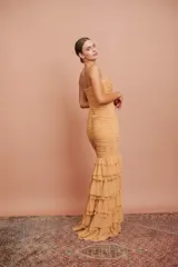 Vestido largo de fiesta color tostado, con escote en V, tirantes finos, cuerpo drapeado y falda sirena con múltiples volados en cascada.