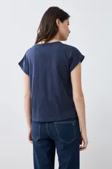 Remera de manga corta con escote en V y detalle de cartera frontal, confeccionada en tejido de punto con textura jaspeada.
