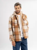 Sobrecamisa de franela con diseño a cuadros en tonos beige y marrón, con capucha integrada de color beige, cierre frontal de botones y bolsillos en el pecho.
